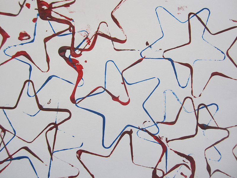 Picture of painting made with star shaped cookie cutters using assorted colors like red and blue.